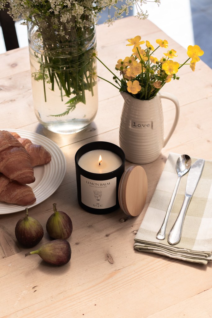 Wick and Fern lit  botanical candle styled on a kitchen table